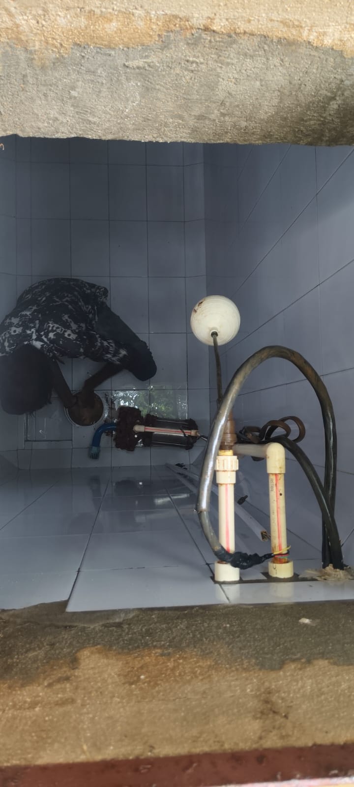 Interior of a cleaned residential water tank showing fittings and equipment after service